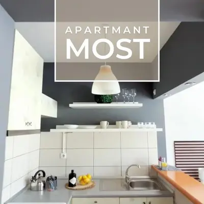 a kitchen with a sink and a sign that reads apartment most at Most apartman in Ruma