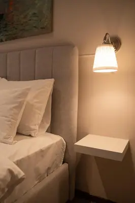 a bed with a lamp next to a side table at Cozy, Comfortable Apt Skadarlija in Belgrade