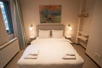 a bedroom with a large white bed with two plates on it at Cozy, Comfortable Apt Skadarlija in Belgrade