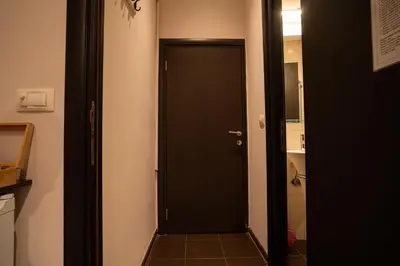 a black door leading to a bathroom with a sink at Cozy, Comfortable Apt Skadarlija in Belgrade