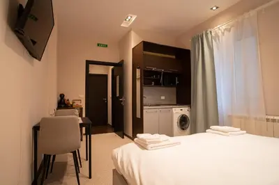 a room with a bed and a table and a kitchen at Cozy, Comfortable Apt Skadarlija in Belgrade