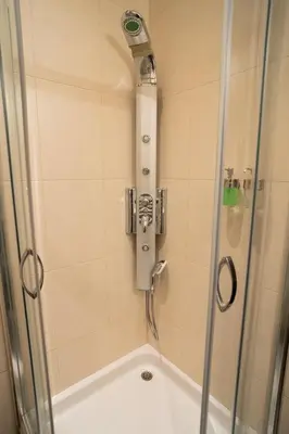 a shower with a glass door and a shower at Cozy, Comfortable Apt Skadarlija in Belgrade