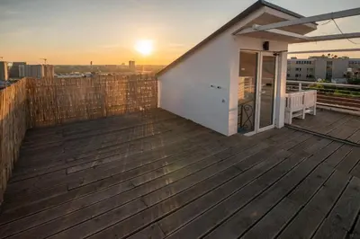 a house on a deck with the sunset in the background at Roof terrace in the heart of Belgrade in Belgrade