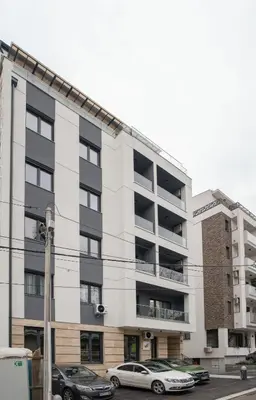 an apartment building with cars parked in front of it at Pegasus apartments in Belgrade