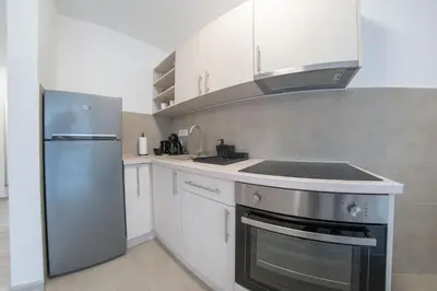 a kitchen with a stainless steel refrigerator and white cabinets at Pegasus apartments in Belgrade