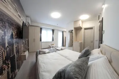 a bedroom with two beds and a couch at Pegasus apartments in Belgrade