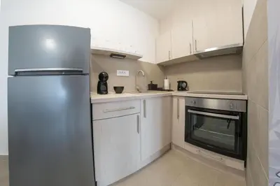 a stainless steel refrigerator in a kitchen with white cabinets at Pegasus apartments in Belgrade