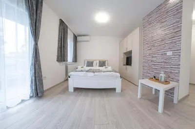 a bedroom with a bed and a brick wall at Pegasus apartments in Belgrade