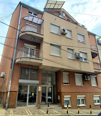 a large brick building with windows and a balcony at Glorry M in Belgrade
