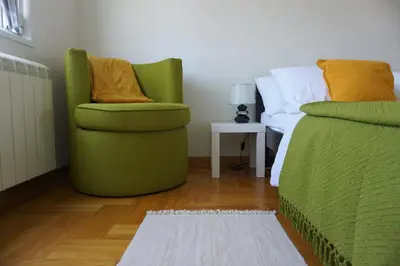 a bedroom with two green chairs and a bed at Dolce Vita Apartment in Belgrade