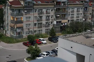 a view of a parking lot with cars parked in front of a building at Dolce Vita Apartment in Belgrade