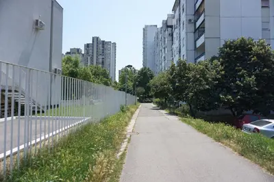 an empty sidewalk next to a fence in a city at Dolce Vita Apartment in Belgrade