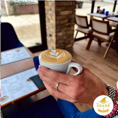 a woman is holding a cup of coffee at Biser in Filmski Grad