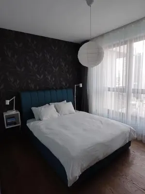 a bedroom with a large bed with a blue headboard at 2-Bedroom Oasis in the heart of the Waterfront in Sajmište