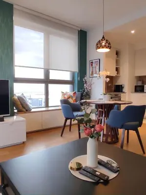 a living room with a vase of flowers on a table at 2-Bedroom Oasis in the heart of the Waterfront in Sajmište