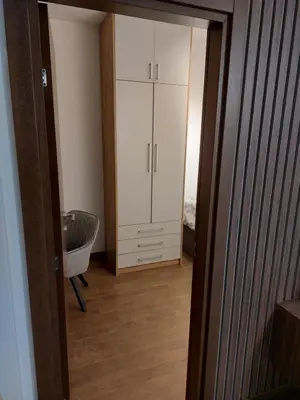a room with a white cabinet and a chair at Apartman M 21 in Karaburma
