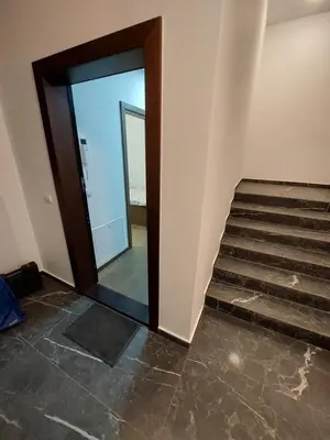 a stairway with a mirror and a glass door at Apartman M 21 in Karaburma