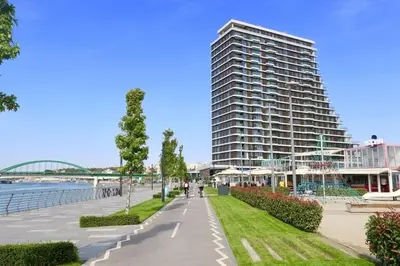 a large building next to a walkway next to a building at Belgrade Waterfront Premium in Belgrade