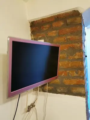 a computer monitor is attached to a brick wall at Hidden Gem on Prime Location in Belgrade