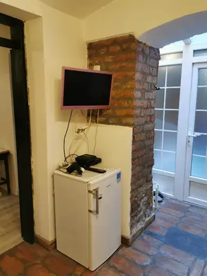 a television on a wall above a small refrigerator at Hidden Gem on Prime Location in Belgrade
