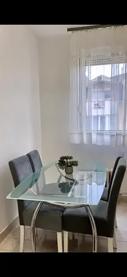 a glass table and chairs in a room with a window at Marina2 in Belgrade