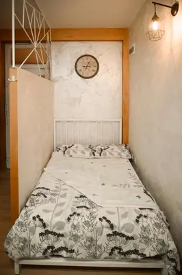 a bedroom with a bed with a clock on the wall at Stan11550 Centar in Lazarevac