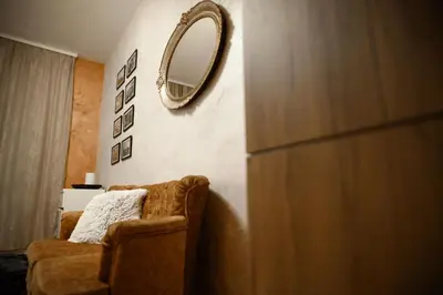a mirror hanging on a wall next to a couch at Stan11550 Centar in Lazarevac