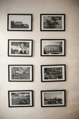 a wall with black framed pictures of cities at Stan11550 Centar in Lazarevac