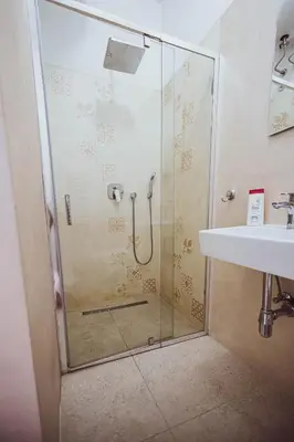 a shower with a glass door next to a sink at BG Exclusive Suites in Belgrade
