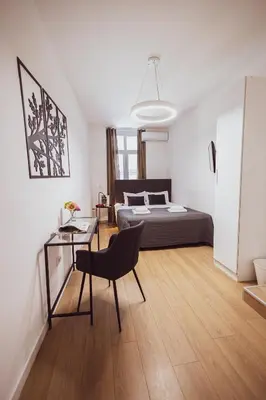 a bedroom with a bed and a table and a chair at BG Exclusive Suites in Belgrade