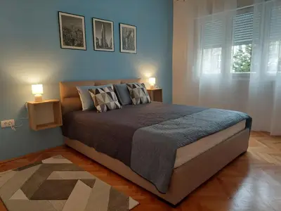 a bedroom with a large bed with two lamps at Dalmatinska apartment in Belgrade
