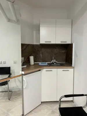 a white kitchen with white cabinets and a sink at Apartman Dunja S in Belgrade