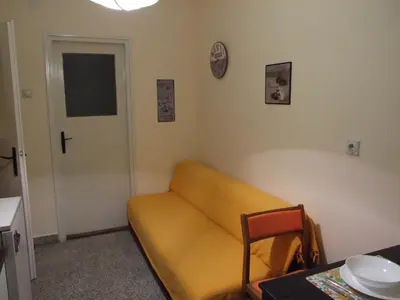 a living room with a yellow couch and a door at Georgina in Rospi Ćuprija