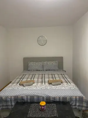 a bedroom with a bed with a clock on the wall at Panorama Royal Vračar in Vračar (historical)