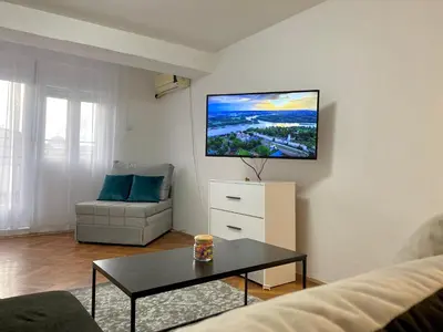 a living room with a couch and a tv on the wall at Panorama Royal Vračar in Vračar (historical)
