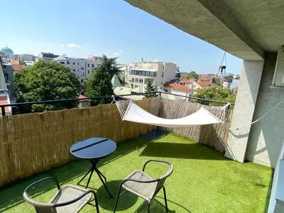 a balcony with chairs and a table and a hammock at Panorama Royal Vračar in Vračar (historical)