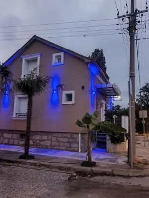 a house with blue lights on the side of it at Apartman Hrkalovic in Arandjelovac
