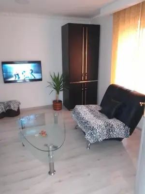 a living room with a glass table and a couch at Apartman Hrkalovic in Arandjelovac