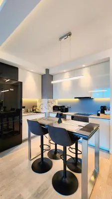 a kitchen with a table and chairs in a room at Belgrade Waterfront 10th fl Lux Apt. w/ City view in Belgrade