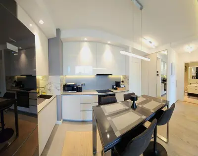 a kitchen and dining room with a table and chairs at Belgrade Waterfront 10th fl Lux Apt. w/ City view in Belgrade