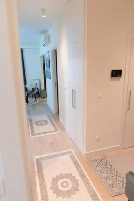 a hallway with white cabinets and rugs at Tommy BW in Belgrade