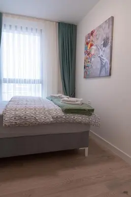 a bedroom with a bed and a window at Tommy BW in Belgrade