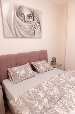 a bedroom with a bed with a painting on the wall at Tommy BW in Belgrade