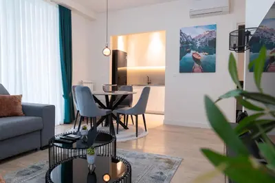 a living room with a couch and a table and chairs at Tommy BW in Belgrade