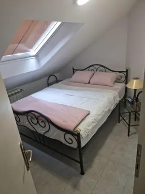 a bedroom with a bed with pink pillows and a window at HEART OF BELGRADE cozy LUX APARTMENT in Belgrade