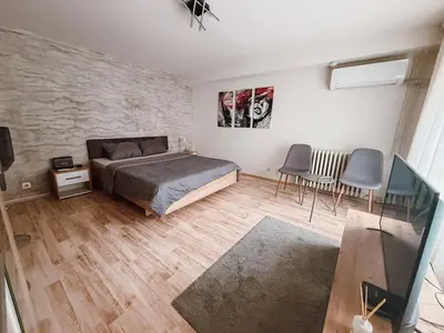 a bedroom with a bed and a table and chairs at Mateja Apartman in Belgrade