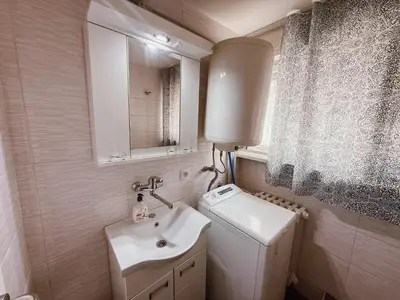 a bathroom with a sink and a toilet and a mirror at Mateja Apartman in Belgrade