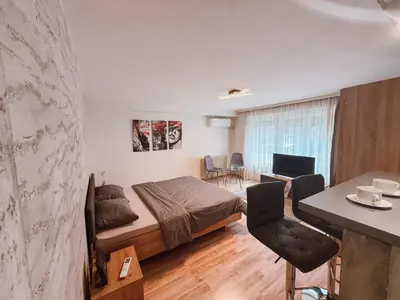 a bedroom with a bed and a table and chairs at Mateja Apartman in Belgrade