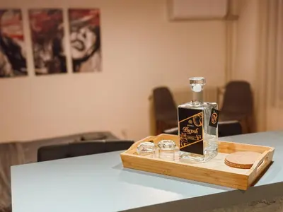 a bottle of whiskey on a wooden tray on a table at Mateja Apartman in Belgrade