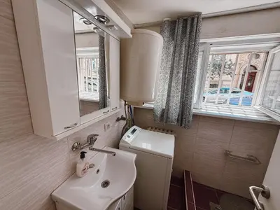 a small bathroom with a sink and a mirror at Mateja Apartman in Belgrade
